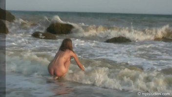 Девушка плещется в море